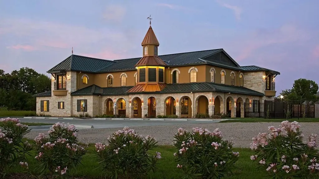 The Rose-Rich Veterinary Clinic building on Thompson Road at dusk, limestone and stucco with a lit octagonal tower